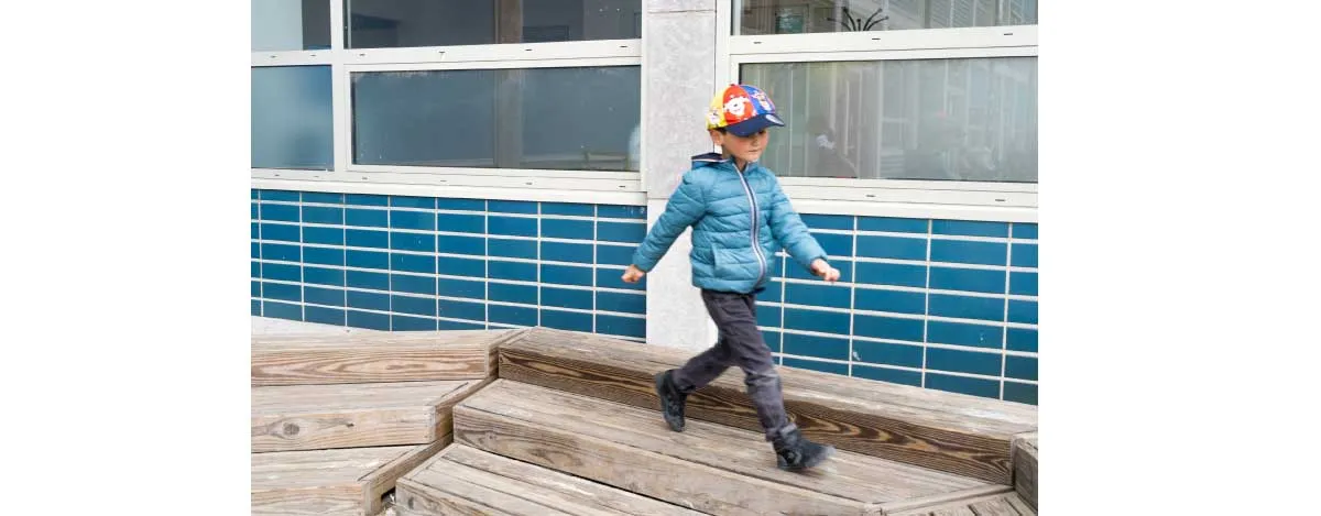 Kind loopt op planken op de speelplaats