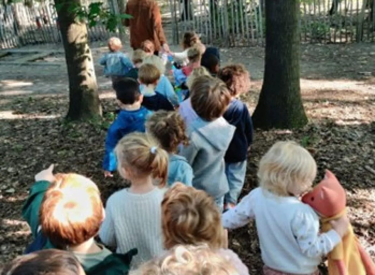 Kinderen met juf onderweg naar het speelbos