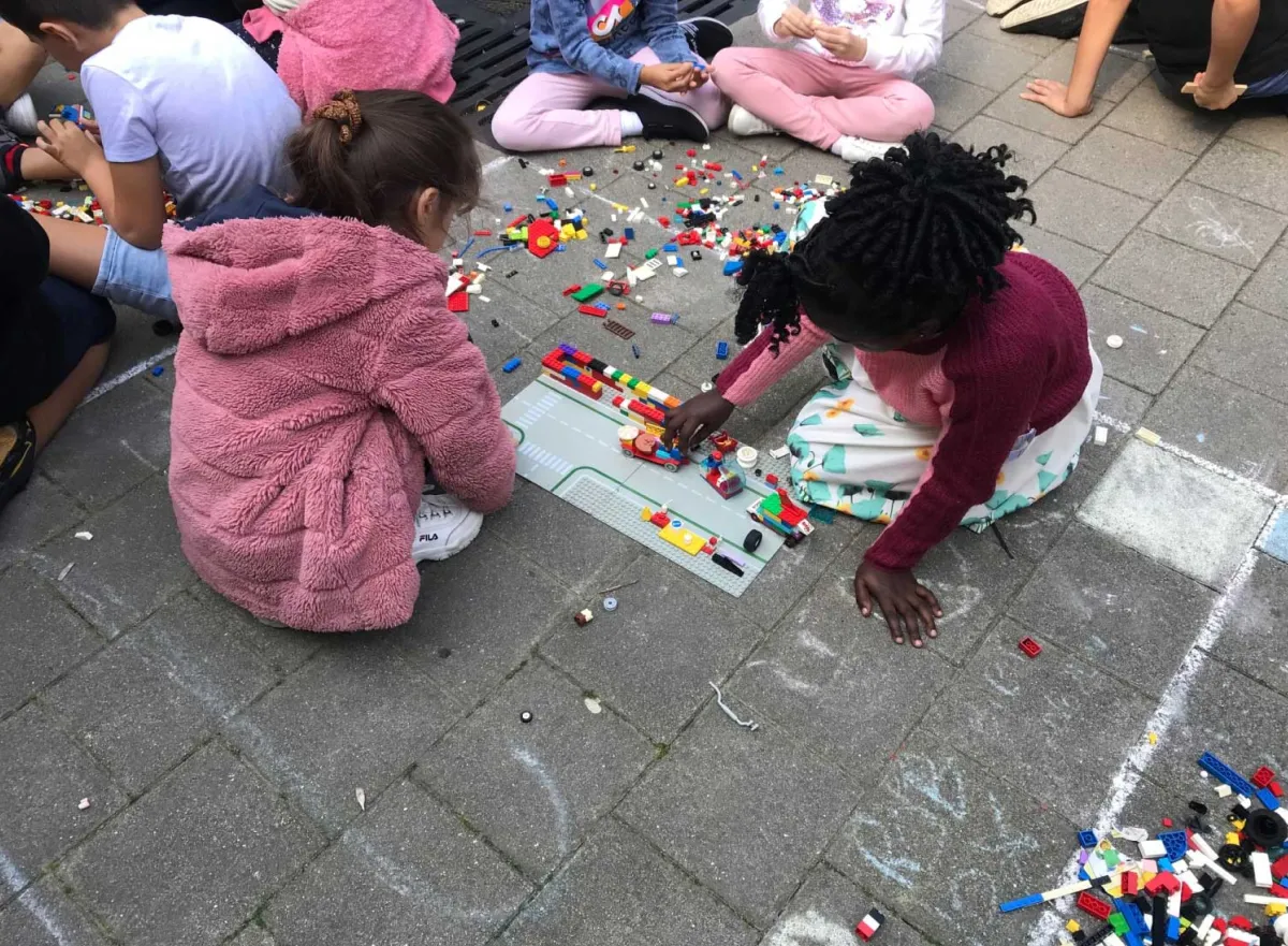 Kinderen spelen met lego op de speelplaats