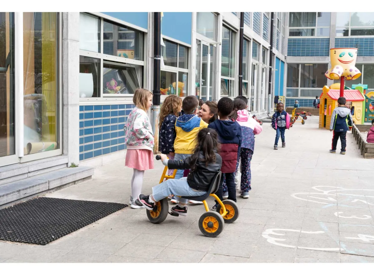 Begeleider met kinderen op de speelplaats