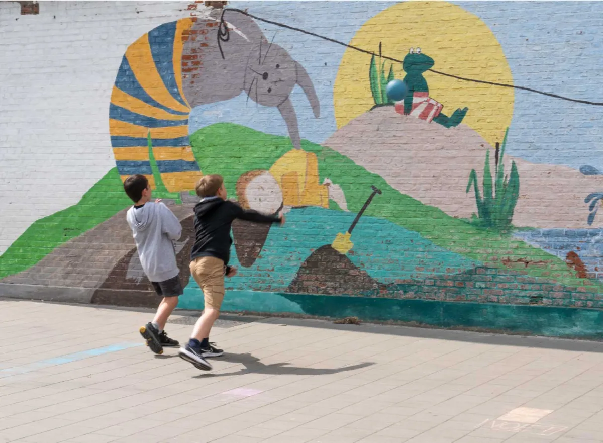 Kinderen spelen balspel tegen de muur op de speelplaats