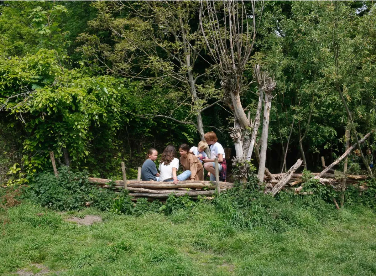 Kinderen zitten samen op plekje in het bos