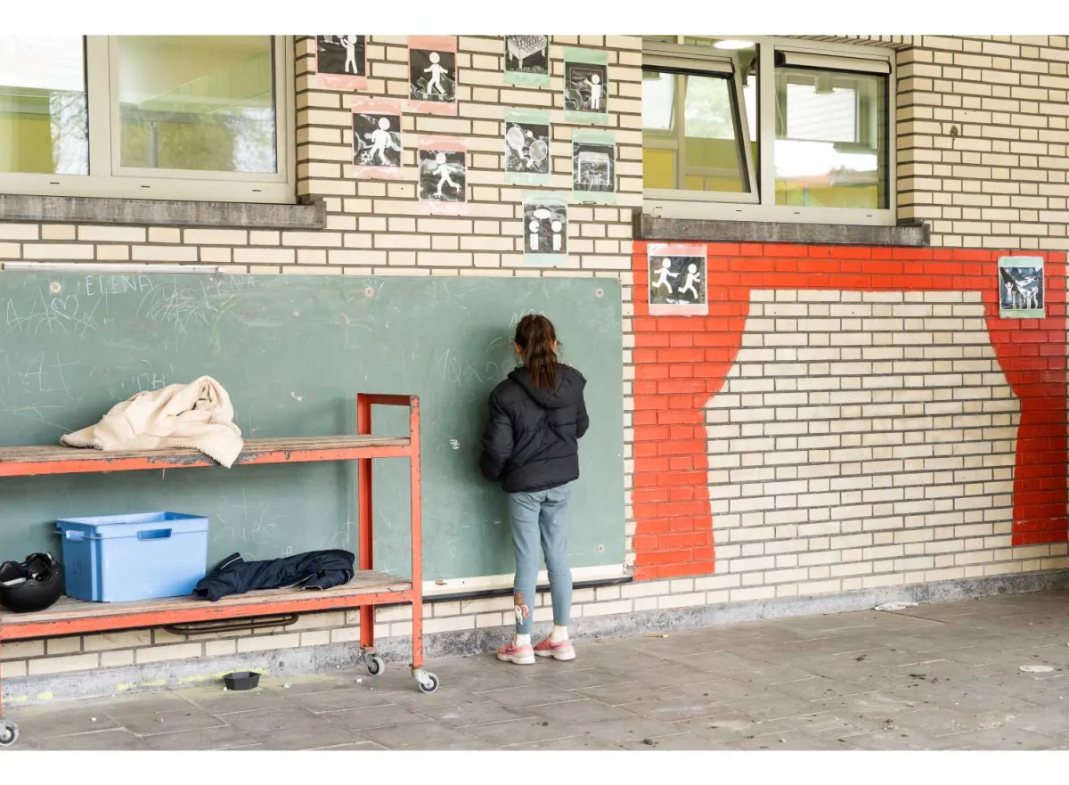 Kind op speelplaats aan schoolbord